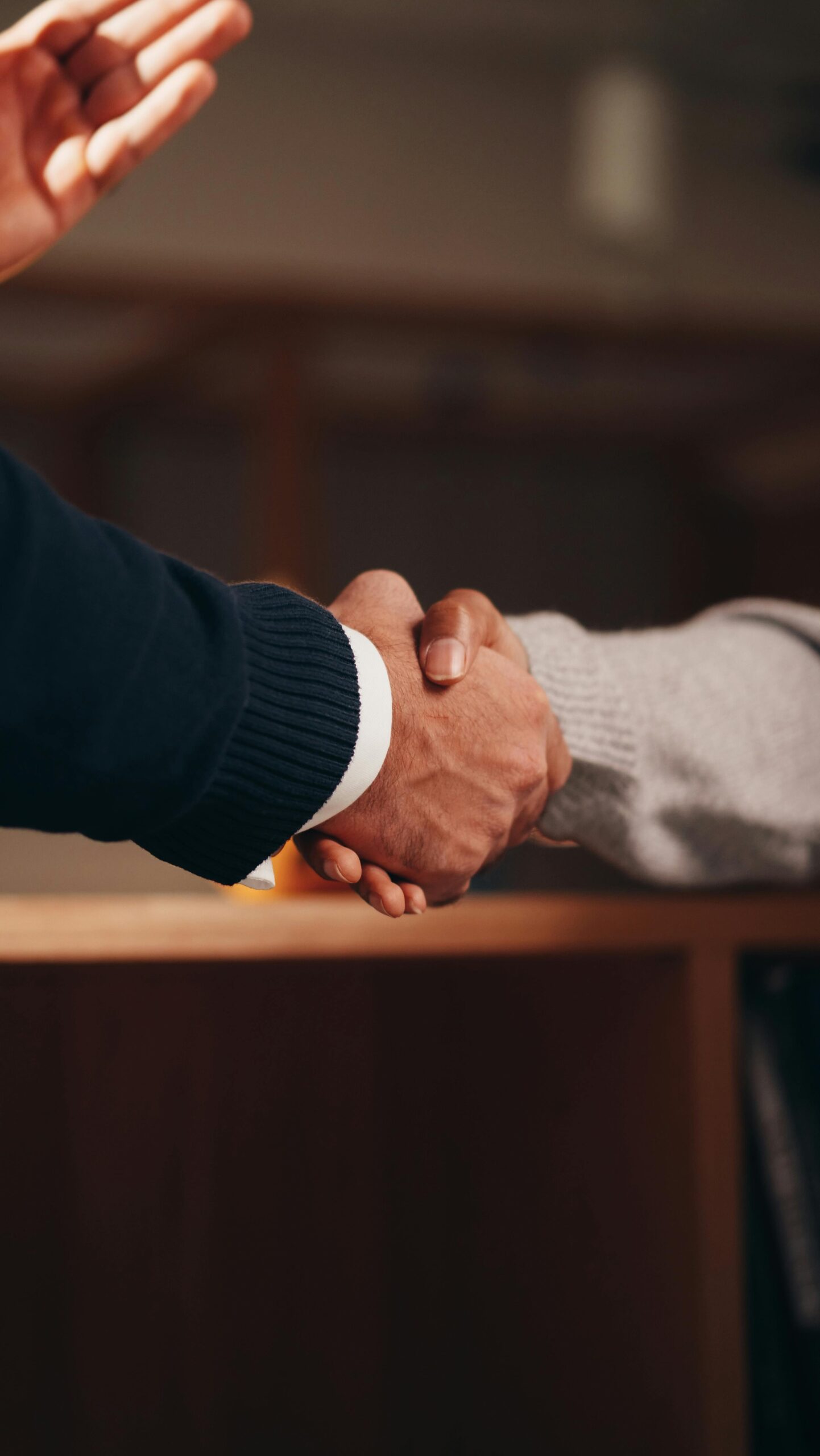 pexels-photo-6773517-6773517 A Person in Black Long Sleeve Shirt Shaking the Hands of a Person in Gray Long Sleeve Shirt